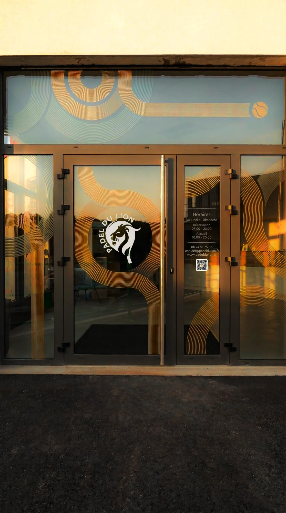 Design de vitrine pour un club de padel à Belfort réalisé par une agence de communication spécialisée en identité visuelle